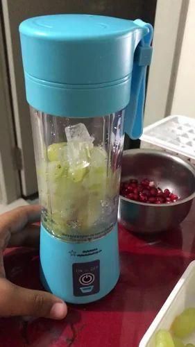 Blue portable blender with ingredients inside on a red surface