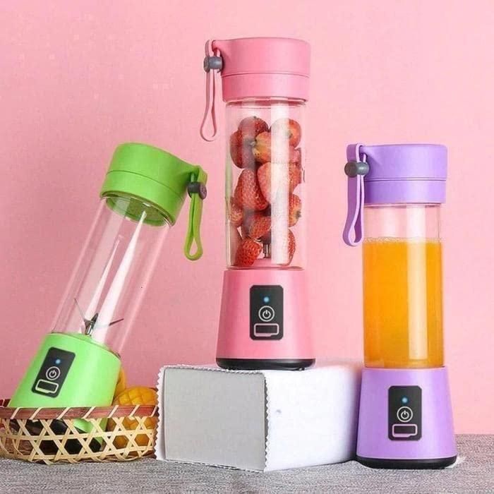Three portable blenders with colorful lids on a pink background