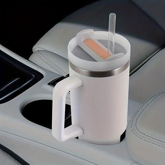 White mug with handle and straw in a car cup holder