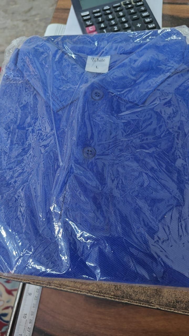 Blue shirt in clear plastic wrap on a wooden surface with a calculator in the background