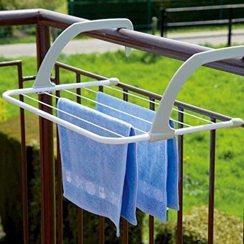 White clothes rack with blue towels hanging on a railing outdoors.
