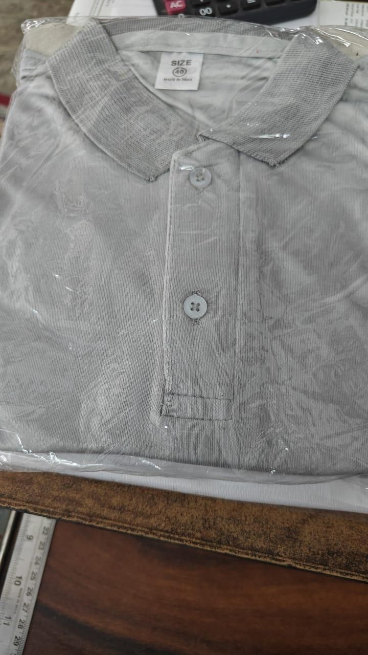 Gray polo shirt on a clear plastic bag with a ruler in the background