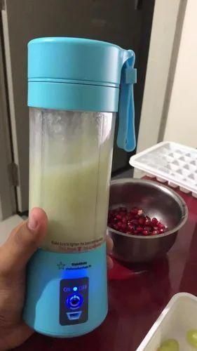 Hand holding a portable blender with a digital display on a kitchen counter.