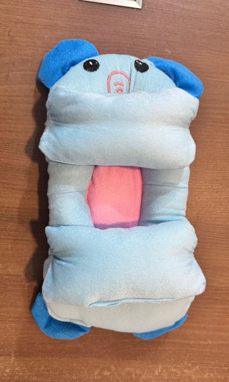 Plush toy resembling a cartoon character on a wooden surface