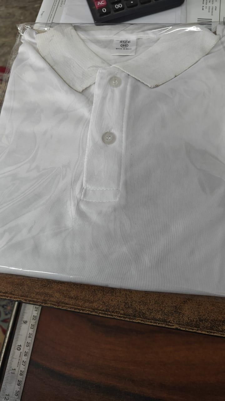 White polo shirt on a table with a ruler in the background