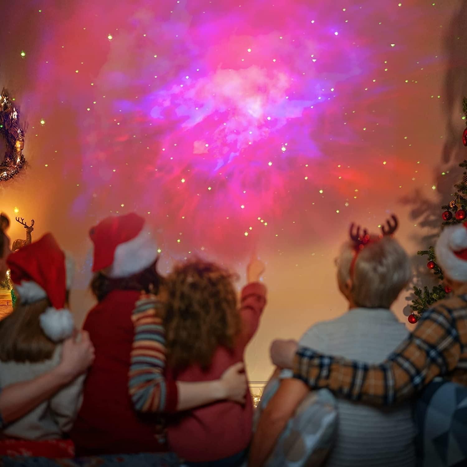 People wearing festive hats and reindeer antlers watching fireworks.