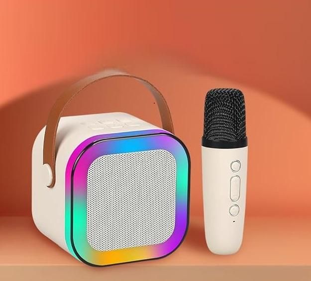 Portable speaker with rainbow lighting and a microphone on an orange background